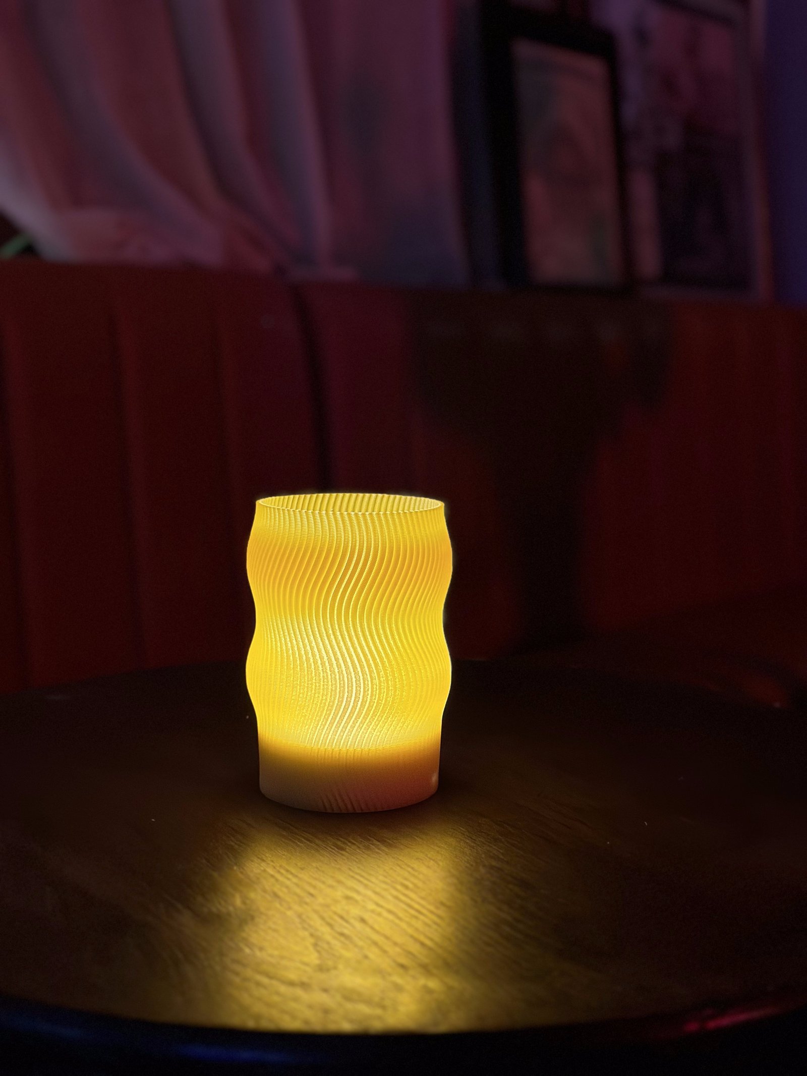 Flow lamp glowing on a dark pub table, close crop